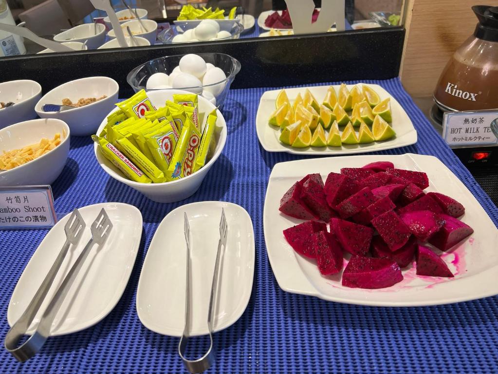 a table with plates of food and utensils on it at Link World Hotel in Taipei