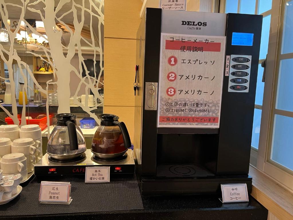 a coffee machine sitting on a counter with cups at Link World Hotel in Taipei