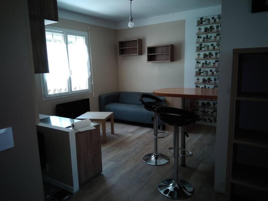 a living room with a couch and a table and chairs at Chaillot 6 in Saintes