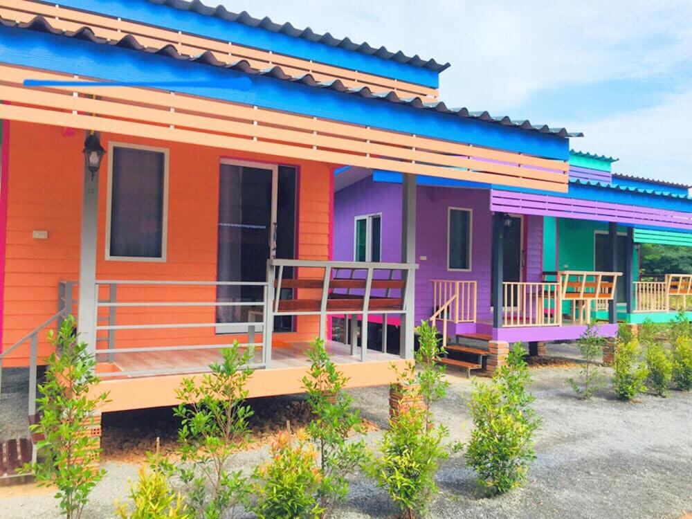 a colorful house with a front porch and a balcony at ณัฐวดี รีสอร์ท in Don Sak