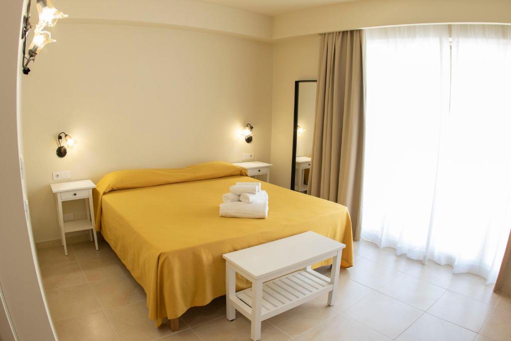 a bedroom with a yellow bed with two towels on it at Verdello Home in Savoca 