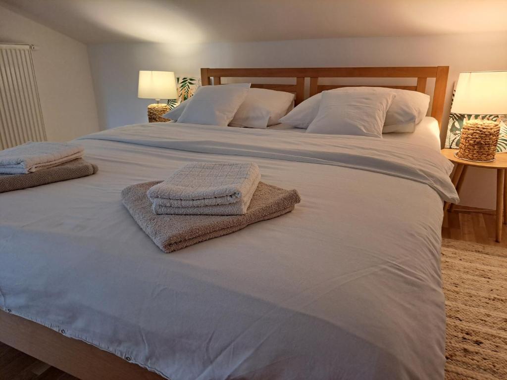 a large white bed with two towels on it at MARENO in Sveta Nedelja