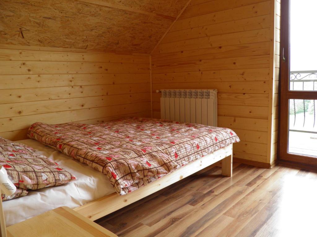 1 dormitorio con 2 camas en una cabaña de madera en Domek pod Lipą, en Korbielów