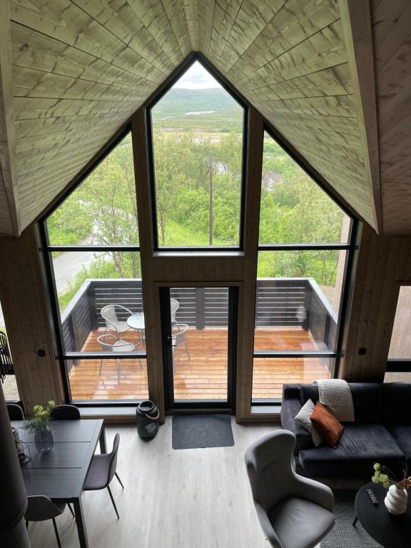 a living room with a large window and a deck at Skaidi Logde- near salomon river and golf course in Hammerfest