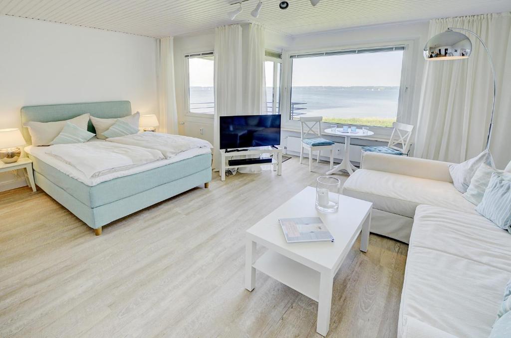 Giường trong phòng chung tại fewo1846 - Fjordview - komfortables Studioapartment mit Balkon und Meerblick