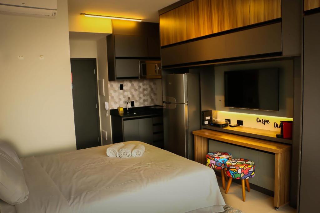 a bedroom with a bed and a kitchen with a sink at Apartamento Palmeiras in Sao Paulo