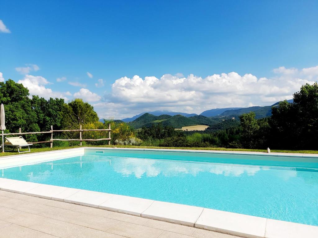 uma grande piscina com montanhas ao fundo em Agriturismo del Frontino - Ca' Benvenuto em Acqualagna