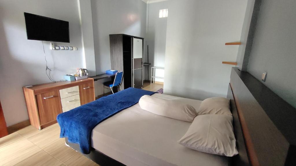 Dormitorio pequeño con cama y TV en OYO 92751 Marang Homestay Syariah, 