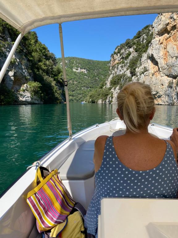 une femme assise sur un bateau sur un plan d'eau dans l'établissement Studio sur les toits, à Villecroze