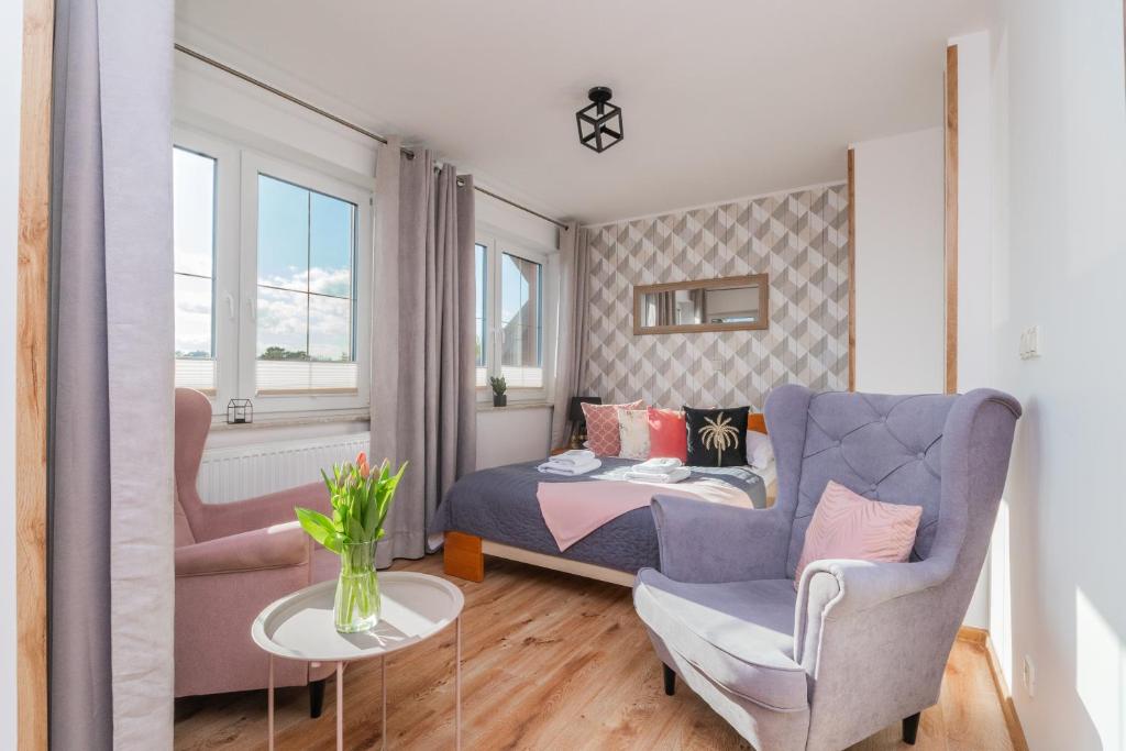 1 dormitorio con 1 cama, 1 sofá y 1 silla en Monika II en Krynica Morska