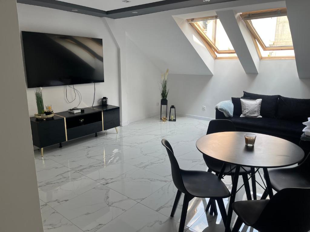 a living room with a couch and a table at Apartament Mazurski Sen in Giżycko