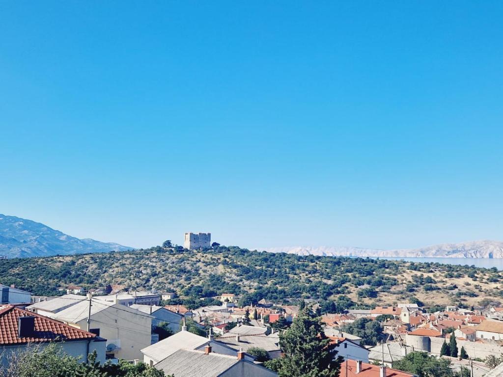 a view of a city with a hill in the background at Guest House Sombrero in Senj