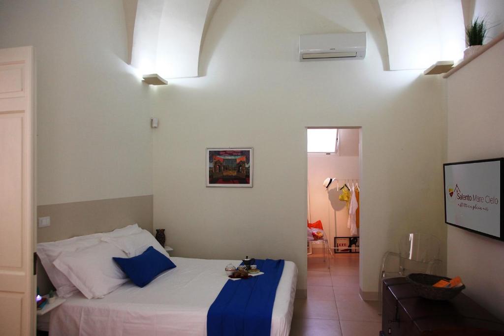 een slaapkamer met een bed met een blauwe deken erop bij Suite San Giuseppe in Nardò