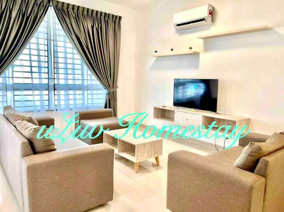 a living room with two couches and a television at Sandy Beach Living near Desaru in Bandar Penawar