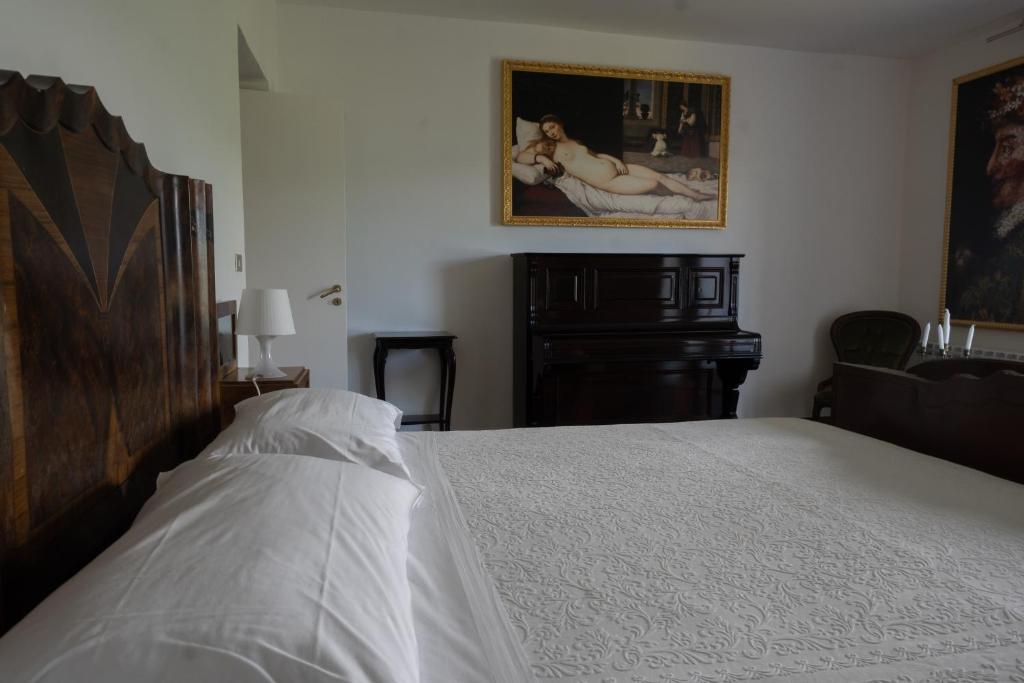 a bedroom with a bed and a painting on the wall at La Casa di Penelope & Cirene in Pietrapertosa