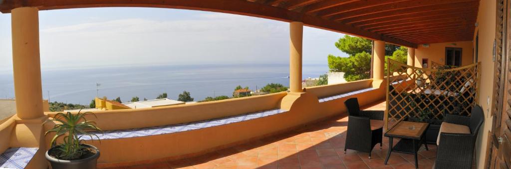 a balcony of a house with a view of the ocean at Solemar Hotel in Leni