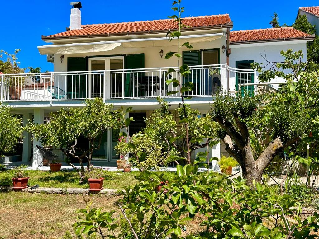 a white house with a balcony and trees at Perla & Palma in Zaboric