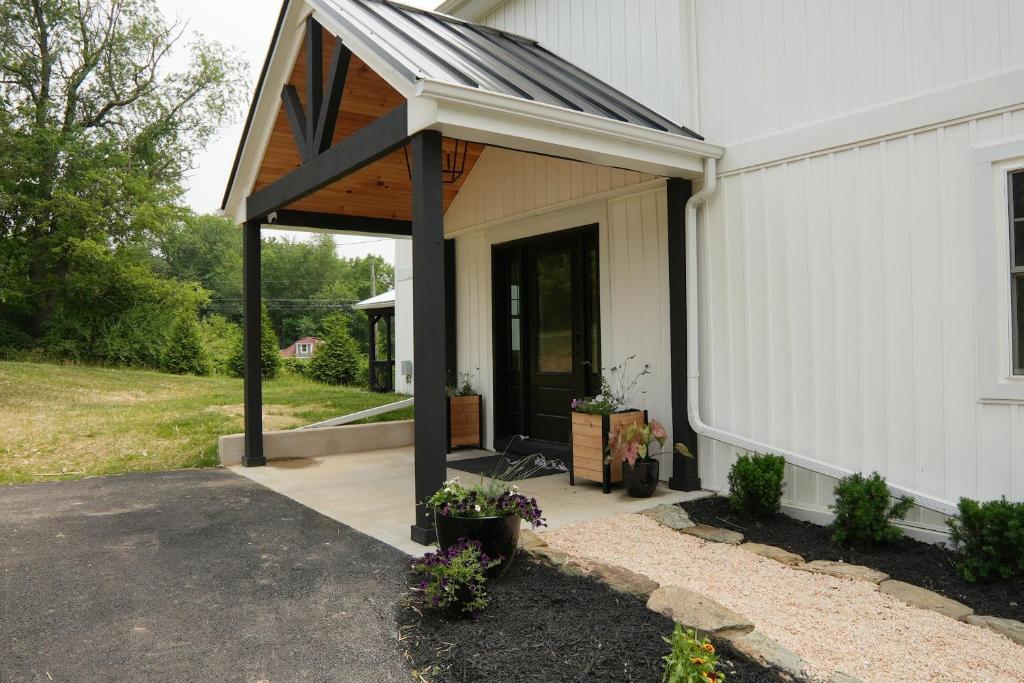 un portico con tenda da sole sul lato di una casa di The Inn at Terra Farms a Glen Rock