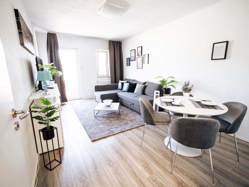 a living room with a couch and a table at City Suite - 5 Min to HBF in Mannheim