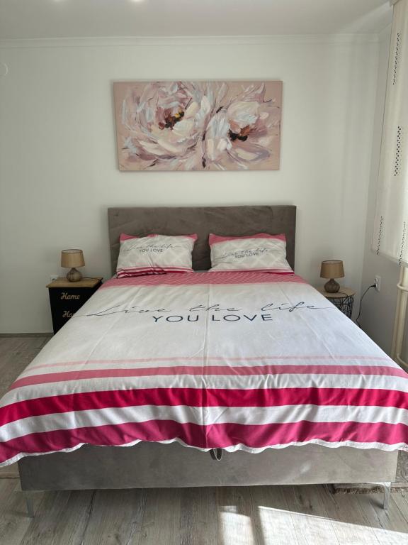 1 dormitorio con 1 cama con manta de rayas rosa y blanca en STUDIO APARTMAN PAVIĆ, en Vinkovci