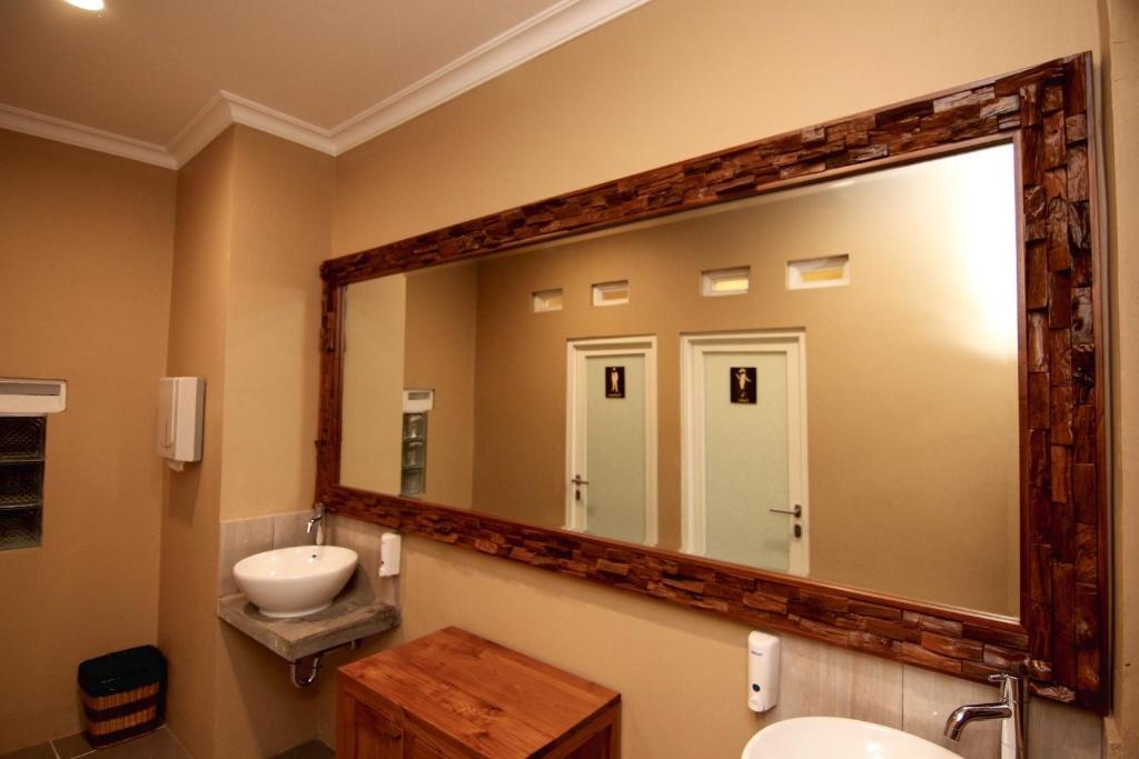 bagno con grande specchio e lavandino di Syailendra Hotel Syariah a Jepara
