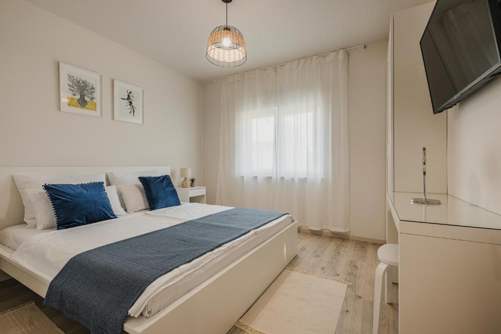 a bedroom with a large bed with blue pillows at 3Level Apartments Kroatien in Umag