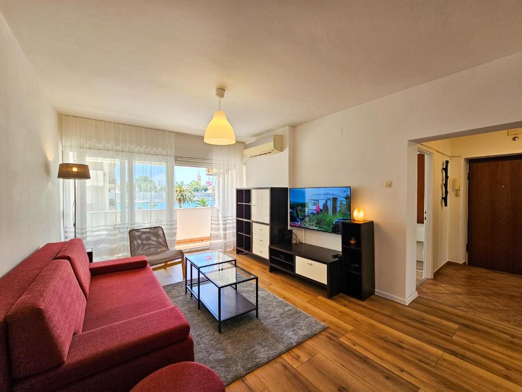 a living room with a red couch and a flat screen tv at Apartment Mari in Zadar