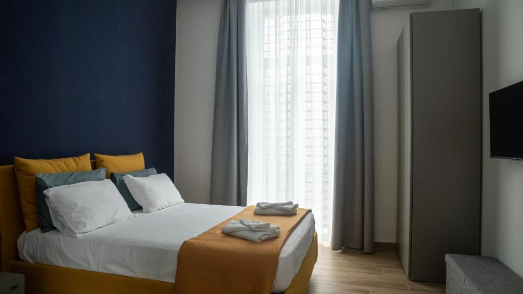 ein Schlafzimmer mit einem Bett und einem großen Fenster in der Unterkunft Urban Loft Napoli in Neapel