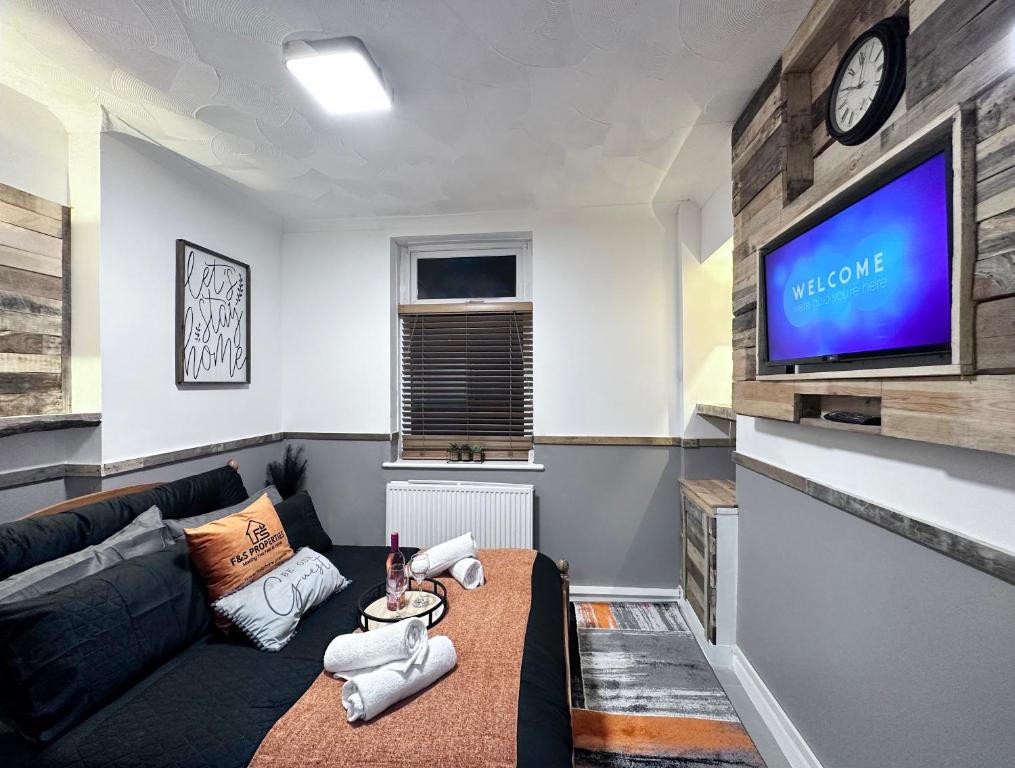 Llwyn-y-pia的住宿－Rustic Rhondda Retreat with Hot Tub & Sauna - Ystrad，带沙发和电视的客厅
