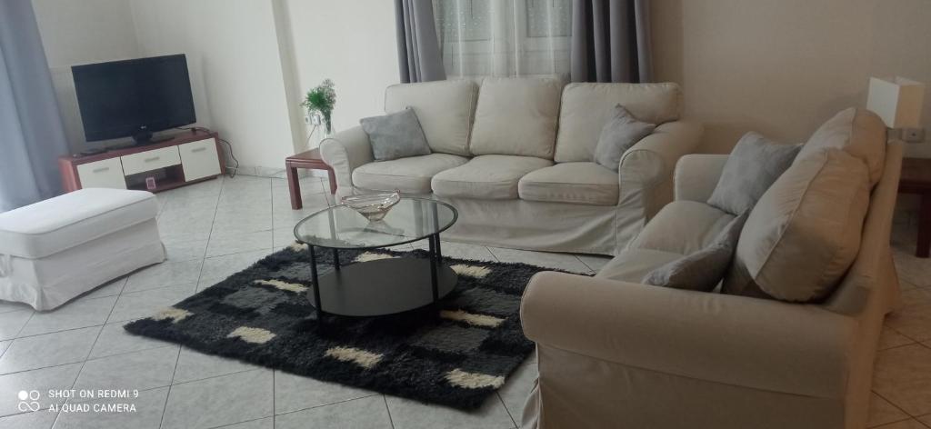 a living room with a couch and a table at Fully Furnished Cozy Stay in Thermi