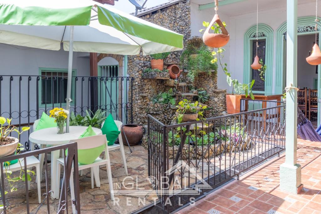卡利的住宿－Sandalio Hostal Cali，一个带桌子和遮阳伞的庭院