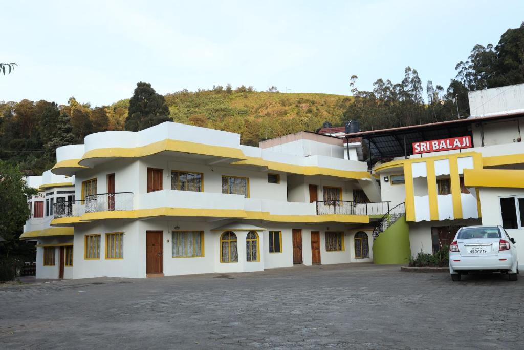 a building with a car parked in front of it at Hotel Sri Balaji in Ooty