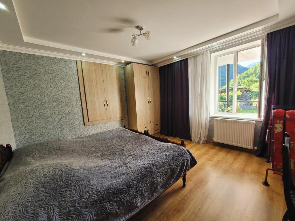 a bedroom with a bed and a large window at Family hotel mountain panorama in Borjomi