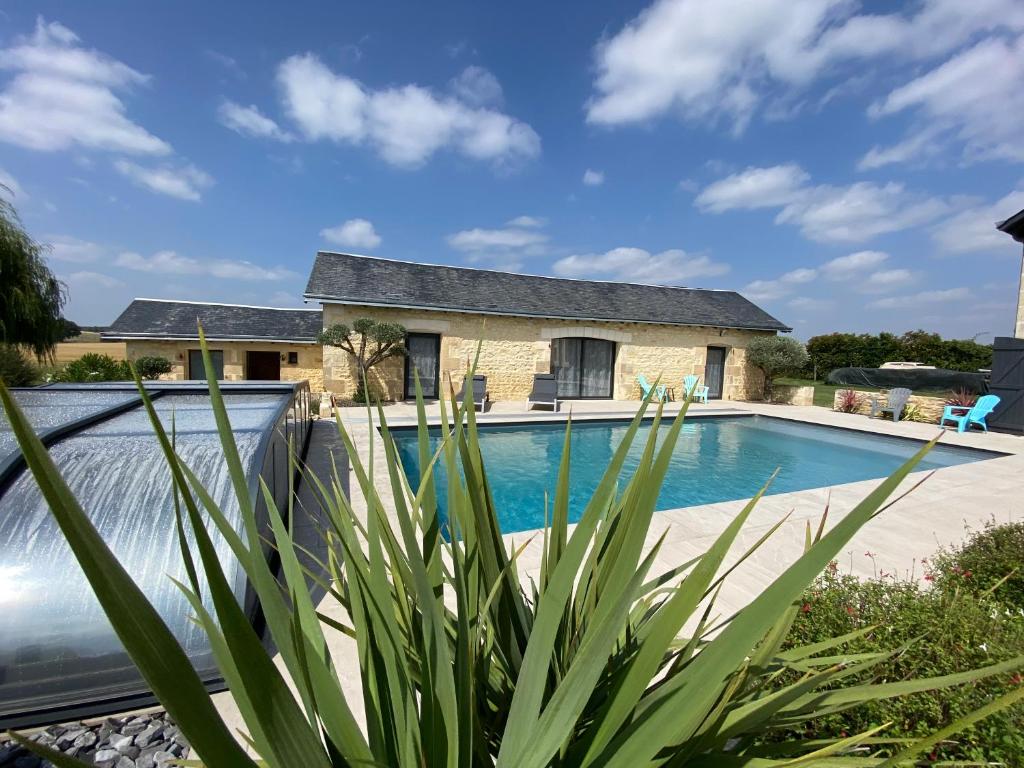 a home with a swimming pool and a house at Longère Linaroise & SPA à 15 min du Futuroscope 