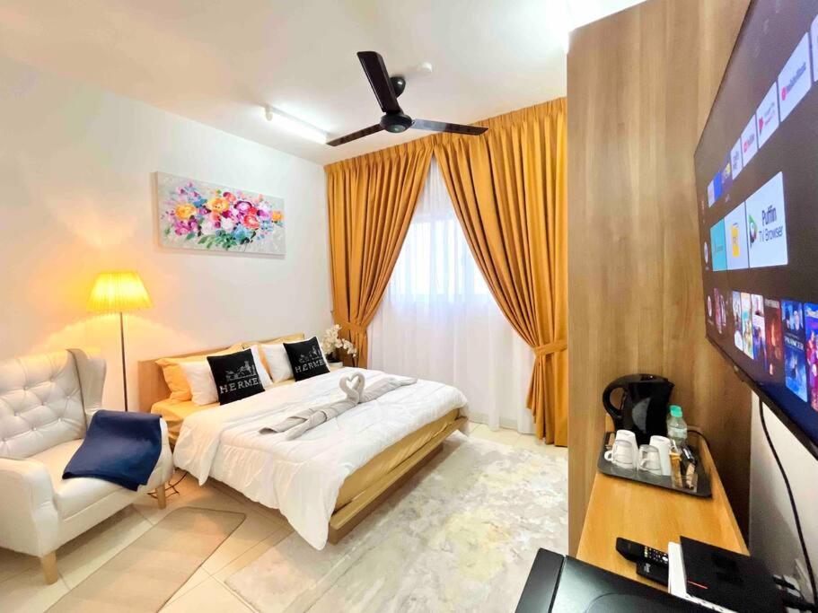 a bedroom with a bed and a flat screen tv at Alanis Studio Suite {shortstay} in Sepang