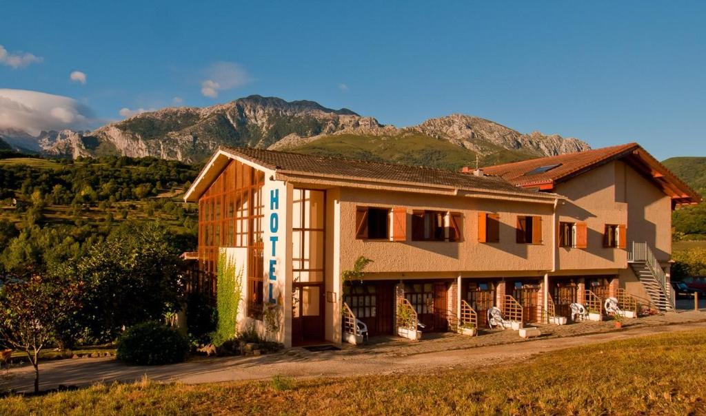 a house with a mountain in the background at Hotel Torrecerredo in Arenas de Cabrales