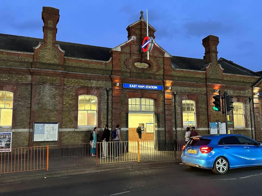 a blue car parked in front of a brick building at Super spacious, Grnd Floor Flat in London