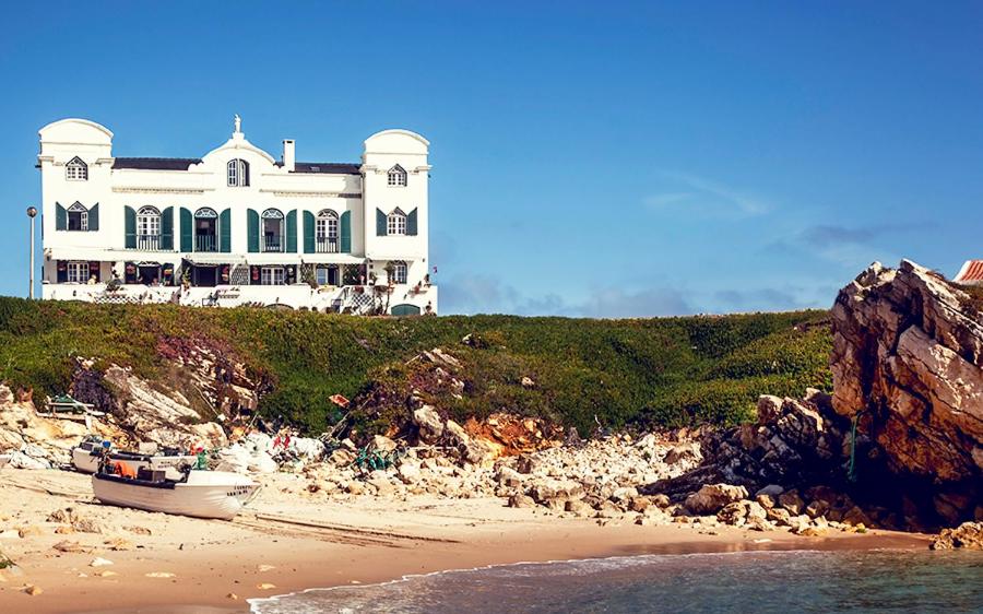 una gran casa blanca en una colina con una playa en Casa das Marés 2 en Baleal