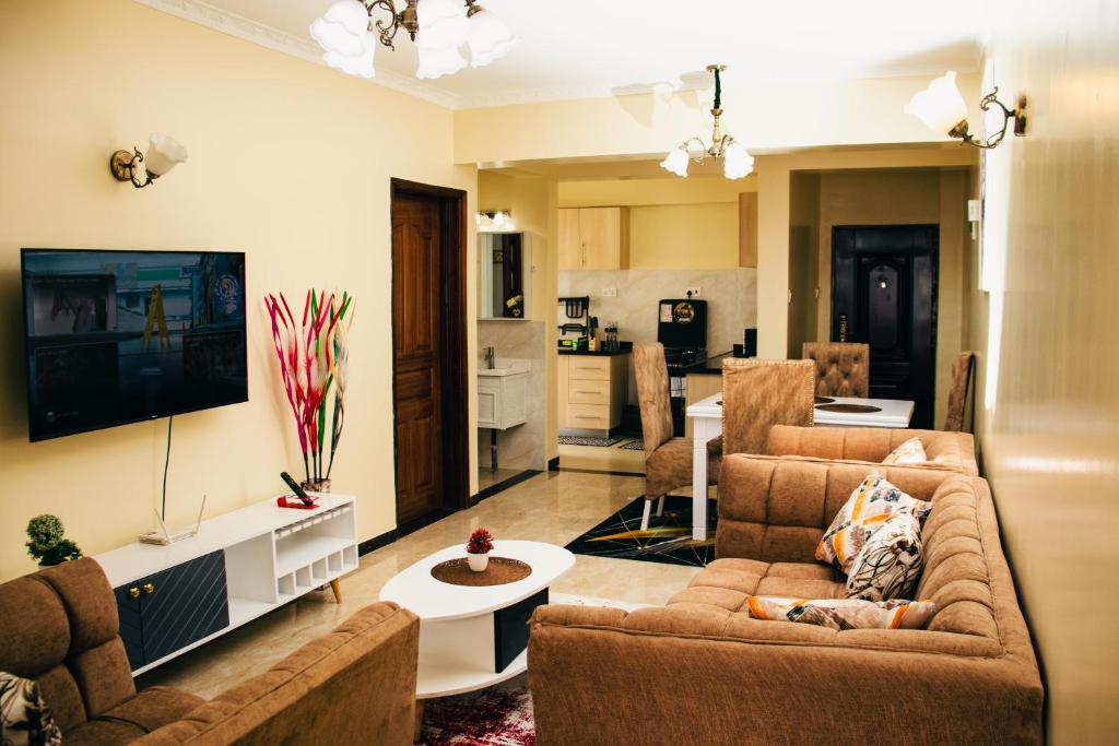 een woonkamer met 2 banken en een tv bij Furnished 2 bedroom apartment in Kilimani in Nairobi