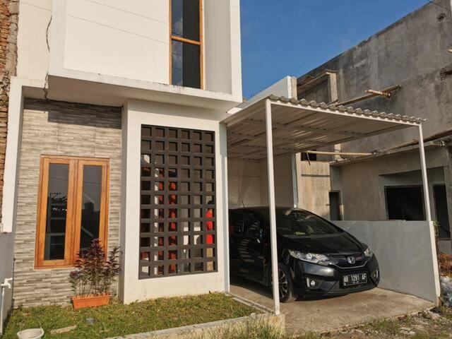 a car parked in a garage in front of a house at Ambarukmo Green Hill / MA 8 in Yogyakarta