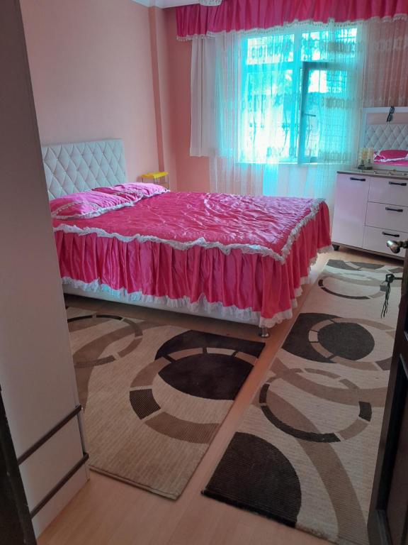 een slaapkamer met een bed met een roze sprei bij Doğa manzaralı ev 