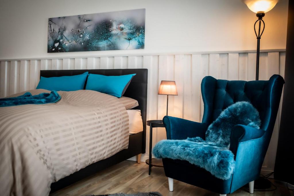 1 dormitorio con 1 cama y 1 silla azul en Modernes Apartment, en Sulz am Neckar
