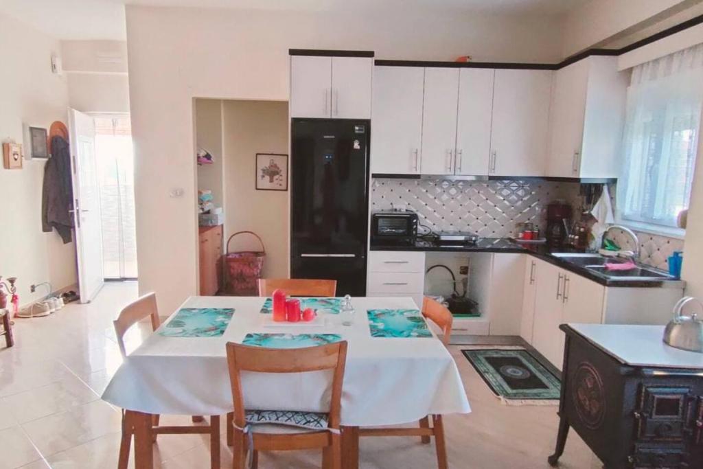 a kitchen with a white table and chairs in a room at Casa con impronta vintage a Nartë 