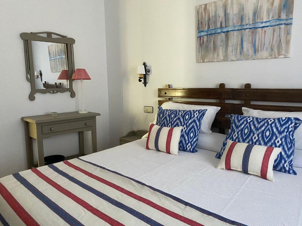 1 dormitorio con 1 cama con almohadas azules y blancas en Hotel Casa de las Piedras, en Grazalema