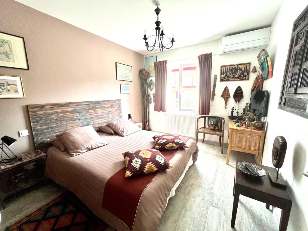 een slaapkamer met een groot bed met kussens erop bij Le 7 in Capbreton