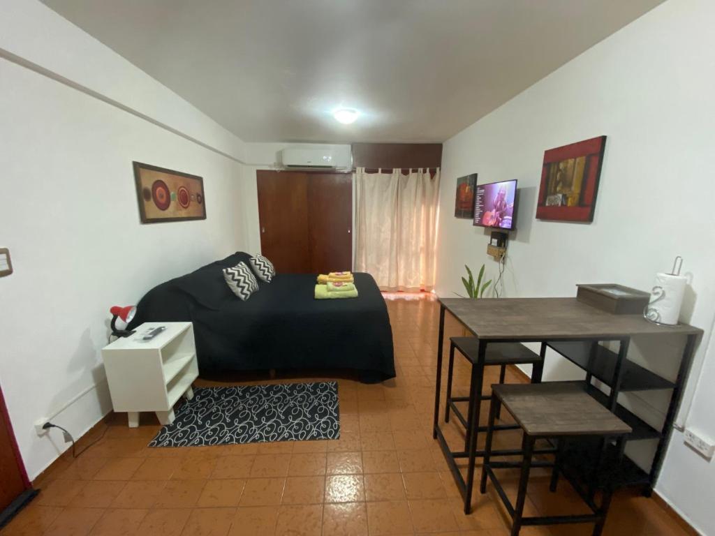 1 dormitorio con cama, escritorio y mesa en Hermoso Monoambiente en Nva Cordoba en Córdoba