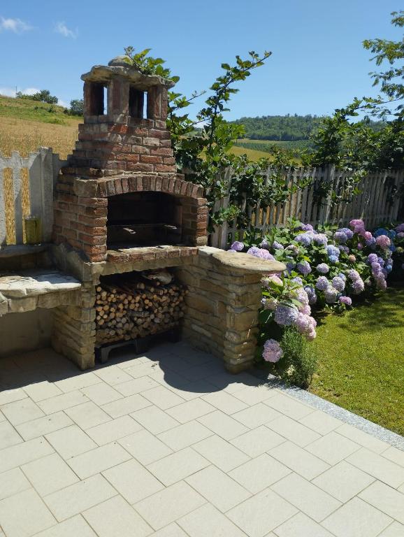 a brick oven in a yard with a fence at Taoretto 1 in Serravalle delle Langhe