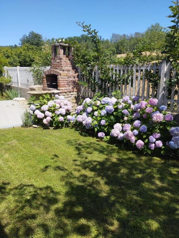 a garden of flowers next to a wooden fence at Taoretto 1 in Serravalle delle Langhe