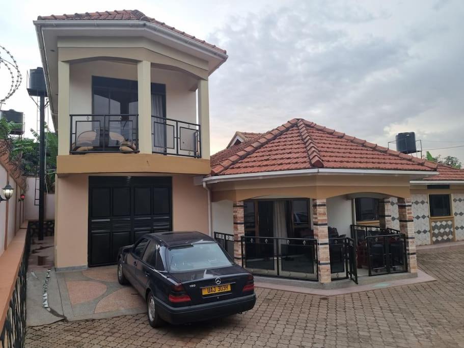 une voiture noire garée devant une maison dans l'établissement Naalya Estate House, à Kampala