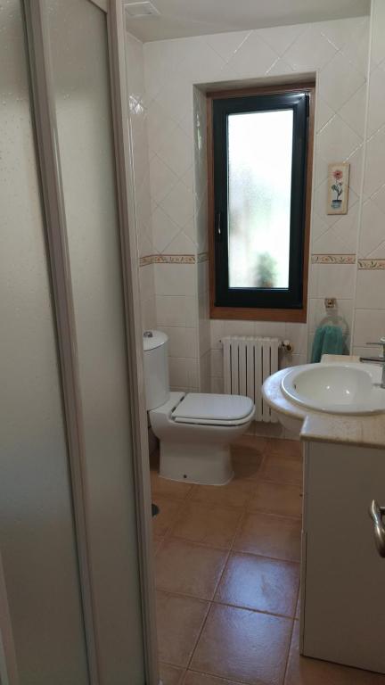 une salle de bain avec toilettes, lavabo et fenêtre dans l'établissement Casa Celita, à Poio